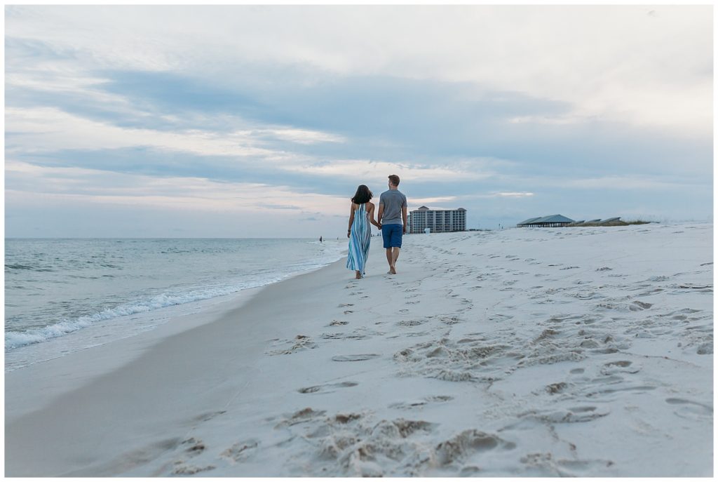 Engaged couple walking away down Johnson Beach, Perdido Key, FL. Pensacola Beach Photographer