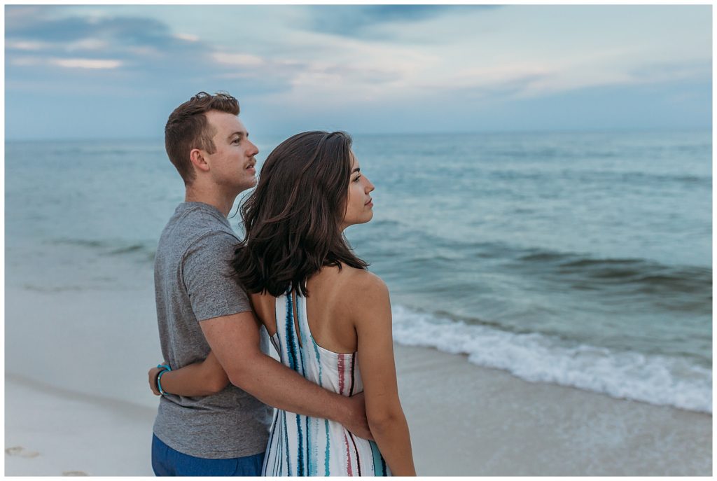 Couple looking out over crashing waves in Perdido Key, FL. Pensacola Beach Photography