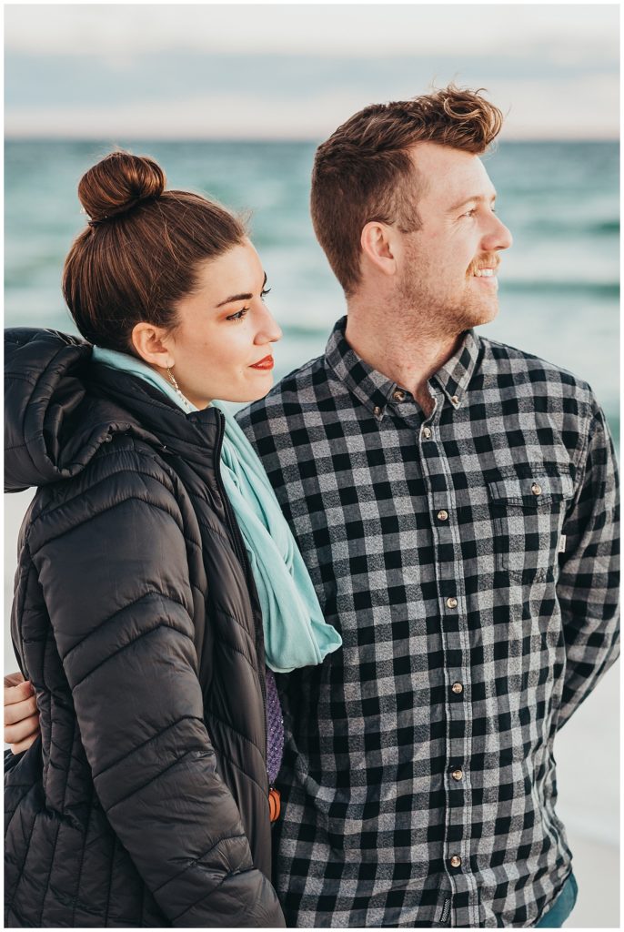 Young couple on vacation looking out over the waves at Pensacola Beach during sunset photos. Pensacola Beach Photography