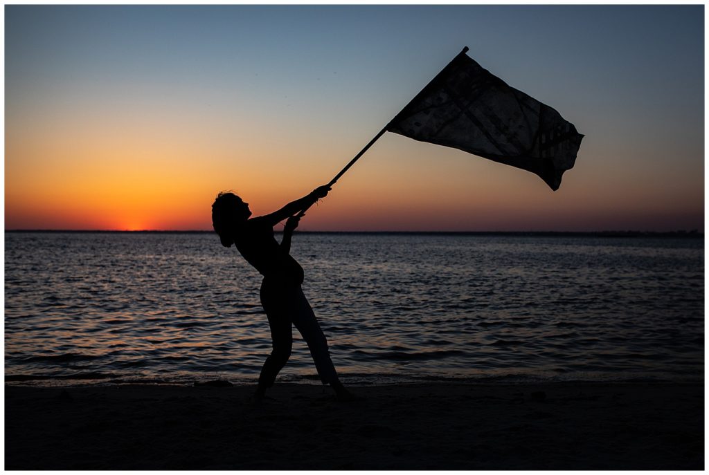 High school senior silhouette image with color guard flag. Pensacola Senior Photographer, Jennifer Beal Photography. 