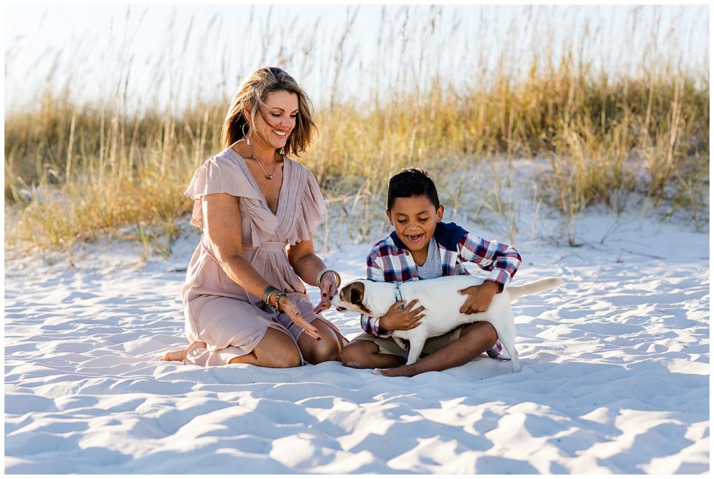 Mother and son playing with their dog on the beach