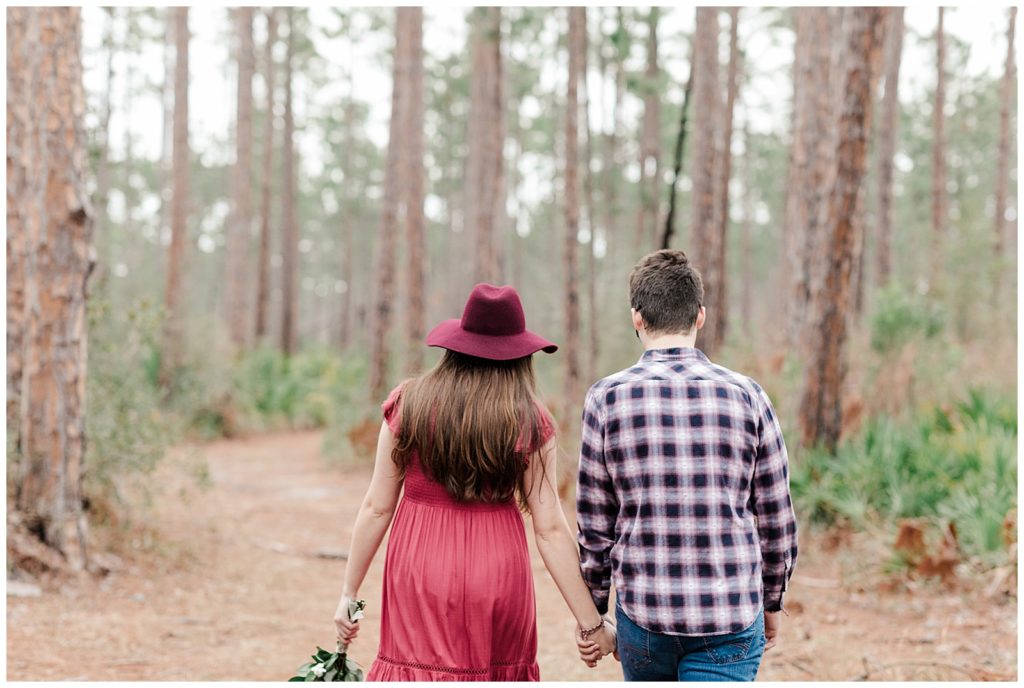 Newly engaged couple walking in the forest at Tarkiln Bayou State Park