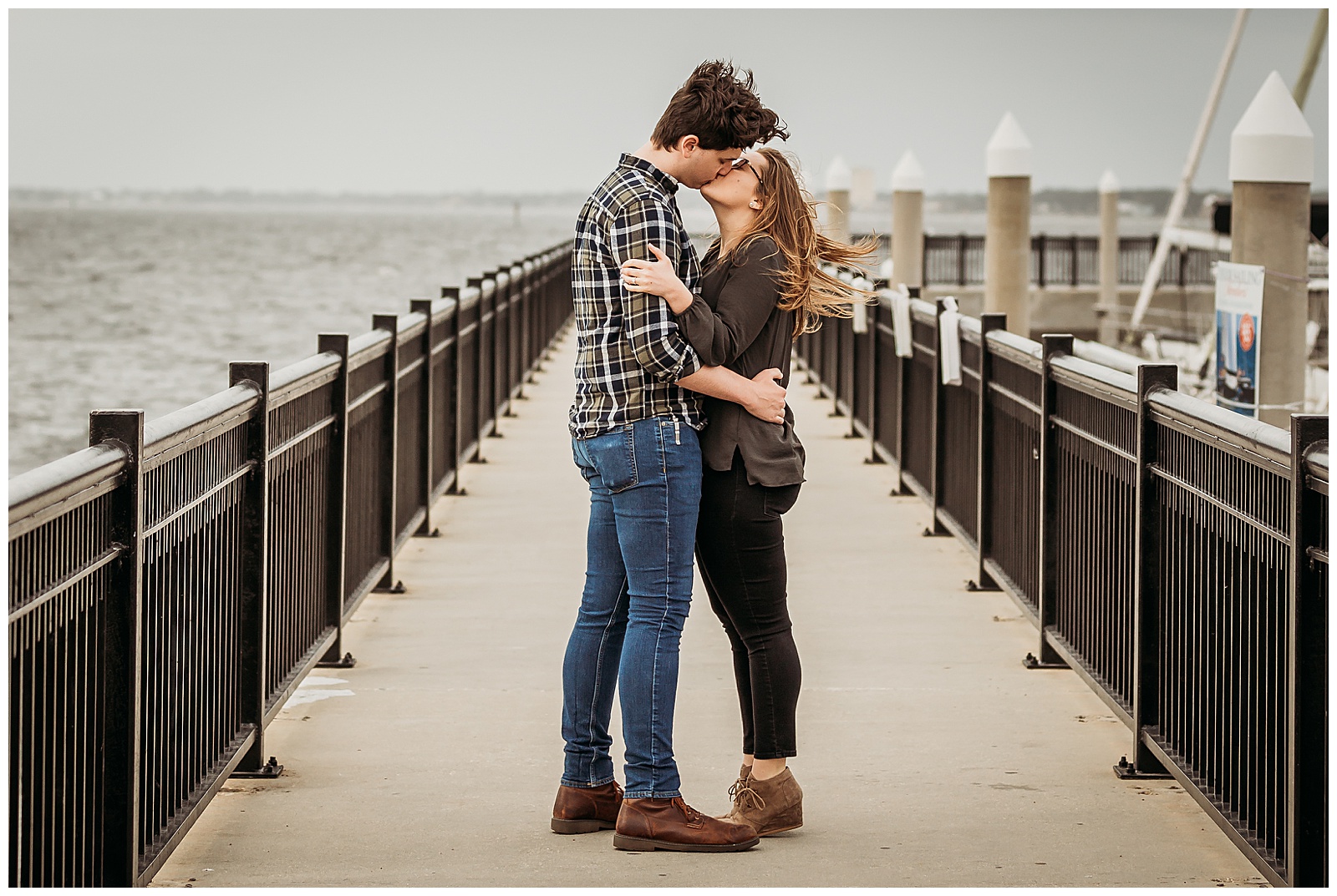 Couple kissing on Palafox Pier during engagement photo session with Jennifer Beal Photography