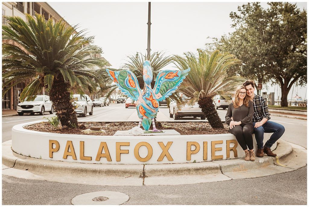 Couple during engagement photo session at Palafox Pier in Downtown Pensacola