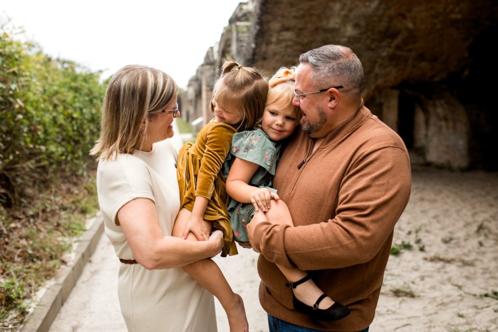 Twin girls playing with grandparents during family photos at Fort Pickens - what to wear during family photos.