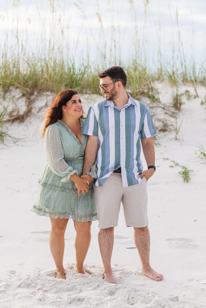 Couple posing on the beach during a family photo session. 