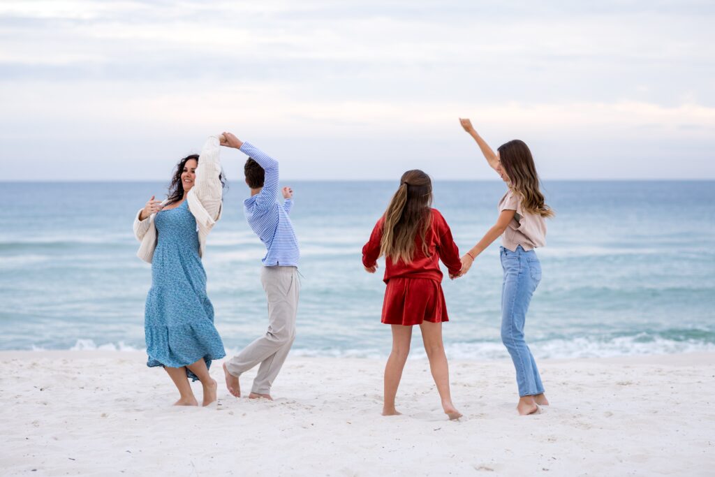 Mom and three teenage children dancing on Pensacola Beach.