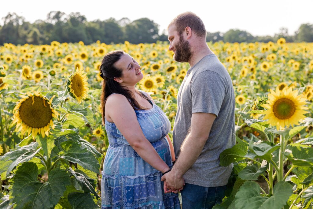Couple in sunflower field during sunflower mini session by Jennifer Beal Photography