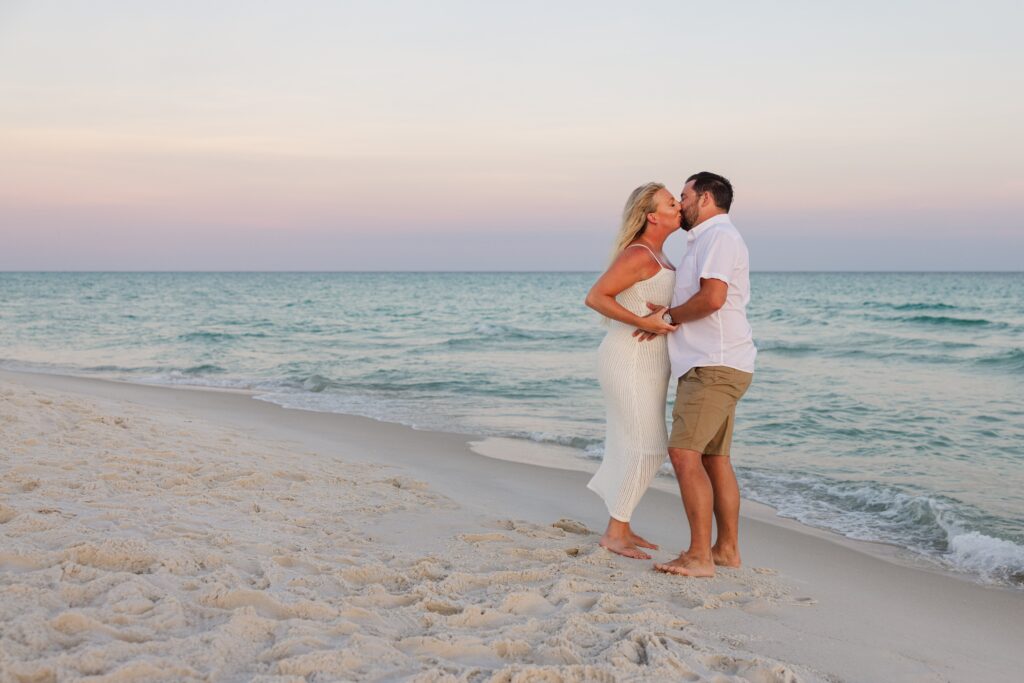 Couple kissing on the beach during Navarre beach family trip.