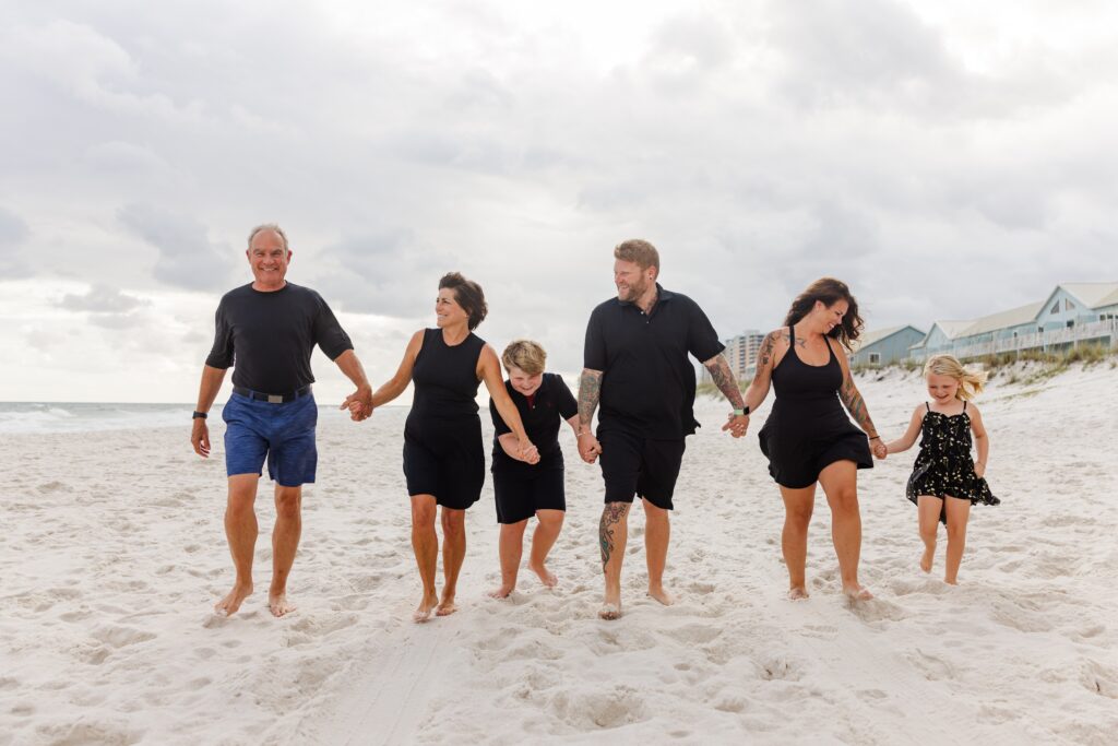 Family walking down Pensacola Beach during family photo session with Jennifer Beal Photography