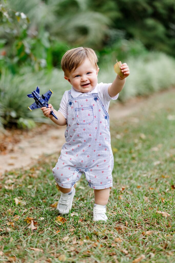 Toddler boy holding Navy Blue Angel as a prop during Baby's First Birthday photo session.