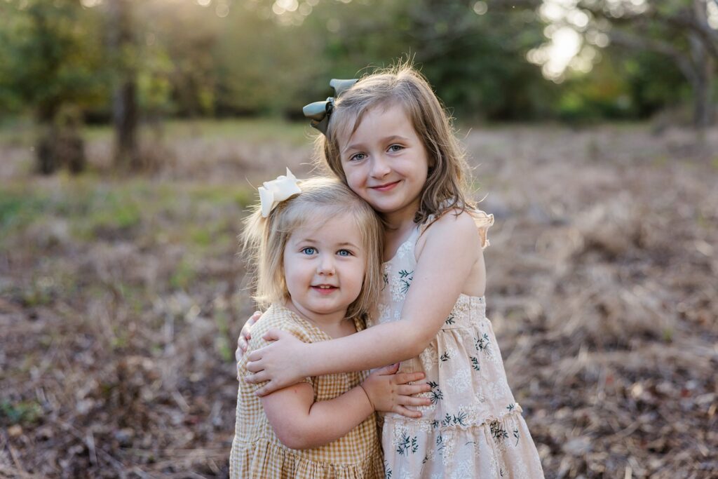 Young sisters hugging each other during photo session