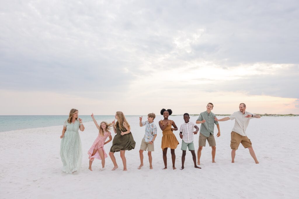 Family of 8 dancing on Pensacola Beach during a photo session by Jennifer Beal Photography