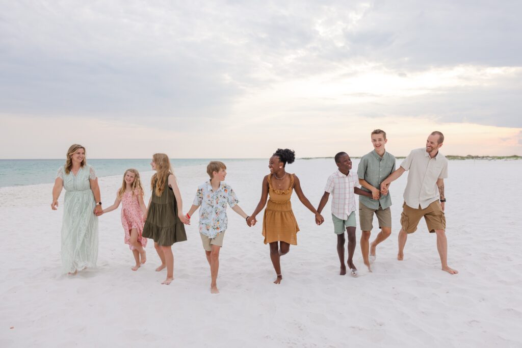 Family walking on beach at sunset during photo session with Jennifer Beal Photography.