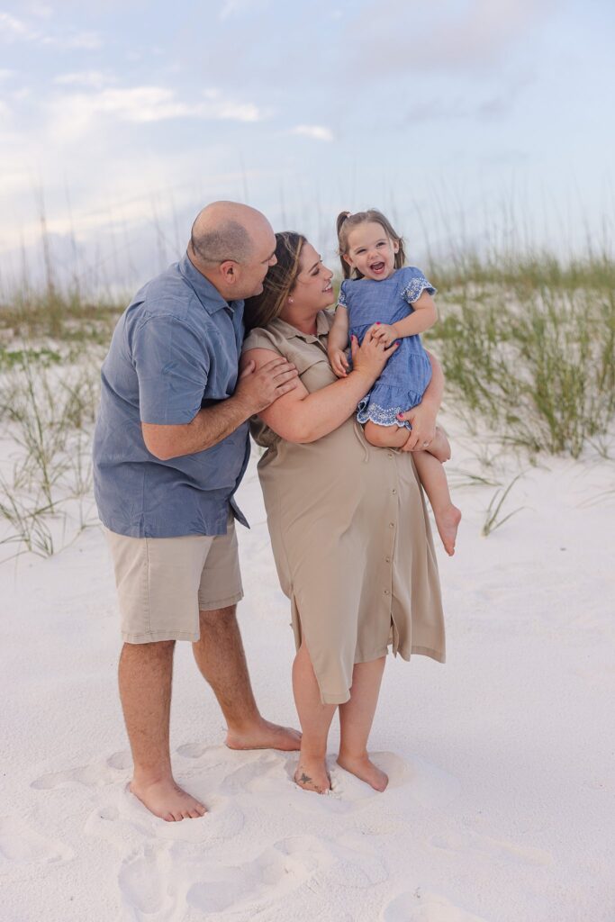 Family of three playing on Pensacola Beach during stress-free family photo session.