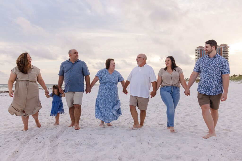 Stress-free family photo session on Pensacola Beach. Family walking towards the camera during sunset. 