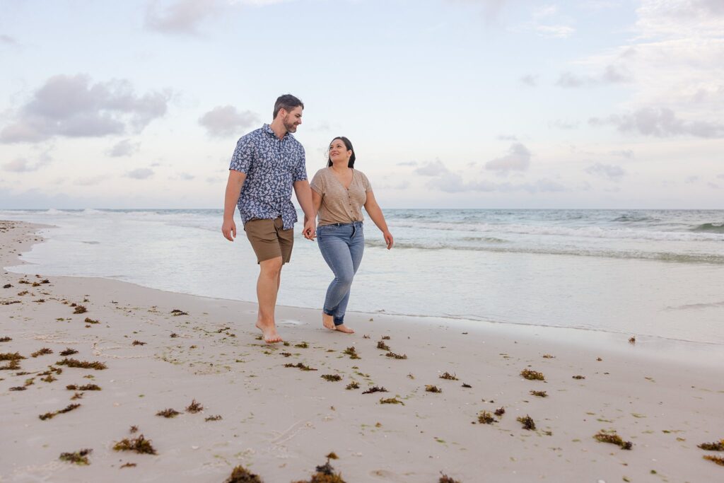 Stress-free family photo session on Pensacola Beach. Couple walking down the beach during sunset. 