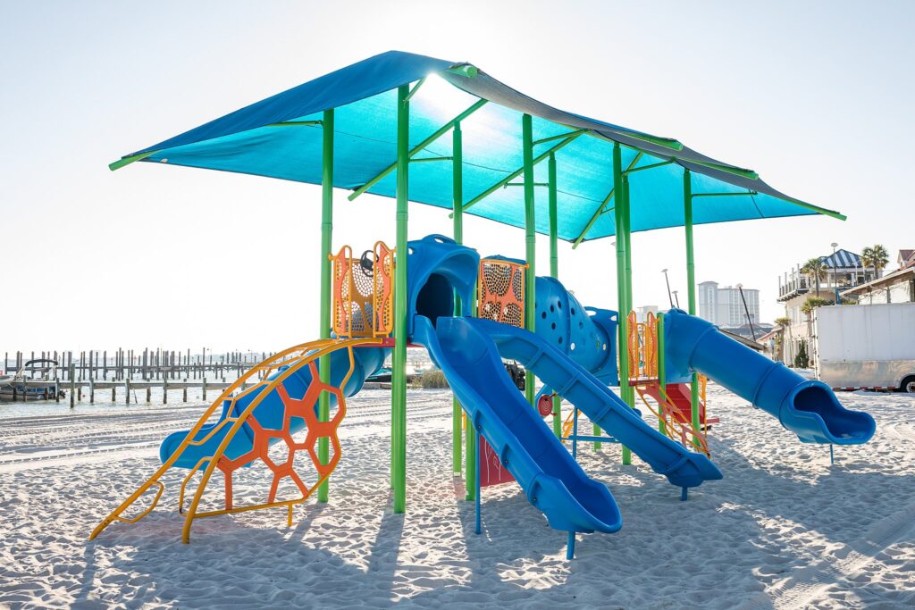 Pensacola Beach Vacation with Toddlers must visit Quietwater Beach playground area with its colorful awning and slides